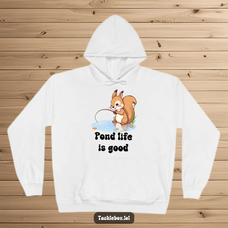 Funny hoodie featuring a playful squirrel with a determined expression, casting a fishing line into a sparkling pond.